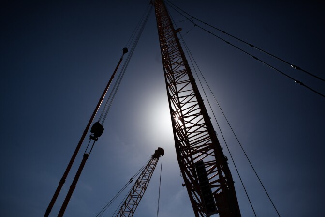 Cranes tower over the initial construction areas of a $1 billion bridge to replace the aging Gerald Desmond Bridge linking the ports of Los Angeles and Long Beach.