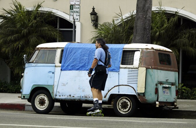 In this file photo, a skater passes a van where a homeless person is sleeping July 13, 2004 in Venice, California. The 9th U.S. Circuit Court of Appeals ruled Thursday that a 1983 law prohibiting people from sleeping overnight in their vehicles was vaguely written and discriminates against homeless and poor people.
