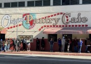 People stand in line under a mural reading: Original Pantry Cafe