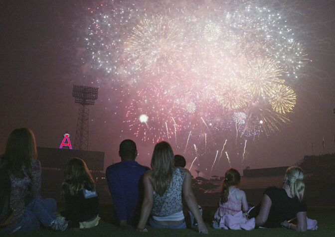 Jose Lima #27 of the Los Angeles Dodgers (C) watches a firework display after defeating the Anaheim Angels on July 4, 2004 at Angel Stadium in Anaheim.