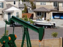 LONG BEACH, CA - MAY 30:  An oil well pumps in a newly constructed neighborhood near Shell Oil Company Alamitos No. 1 discovery well on Signal Hill on May 30, 2003 in Long Beach, California. Alamitos No. 1 was created in 1921 and helped establish California as one of the world's major oil-producing states. The Signal Hill Oil Field, now known as the Long Beach Oil Field, reportedly had the world's highest oil production per acre by the mid-twentieth century. Hundreds of companies and individuals became rich on minute leases, some locations so close that derrick legs overlapped. New housing and stores are now being built among operating oil wells. Farther north, a cancer scare has swept over Beverly Hills High School where environmental activist Erin Brockovich and her boss, lawyer Ed Masry, are alleging that toxic fumes from oil wells on the campus have created a "cancer cluster" that is 20 times higher than the national average.   (Photo by David McNew/Getty Images)