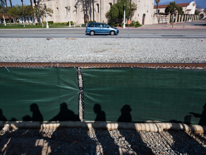 News media and community members listen to San Gabriel's mayor at a press conference. The San Gabriel Mission is across the street from the dig site.