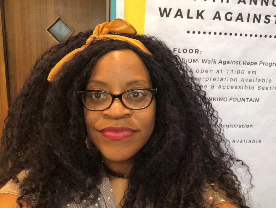 Robin Wilson-Beattie, a Black middle-aged woman, wearing a yellow headband and glasses and taking a selfie.