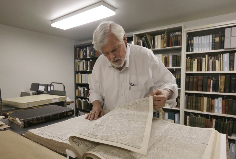 Bob Hirst, general editor of the Mark Twain Project, looks through a book of 1866 Sacramento Union newspapers at The Bancroft Library at the University of California Berkeley in Berkeley, Calif., Monday, May 4, 2015. Scholars at the University of California, Berkeley have pieced together a collection of dispatches written by Mark Twain when the author was a young newsman in San Francisco. (AP Photo/Jeff Chiu)