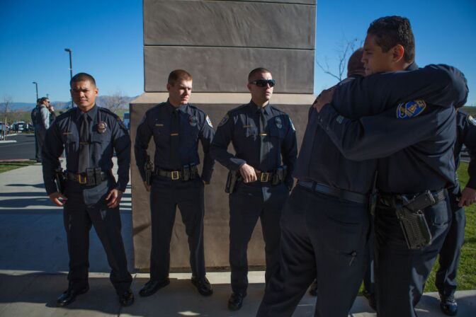 Riverside Police Officers console each other outside of Grove Community Church before Michael Crain's funeral on February 13th, 2013.