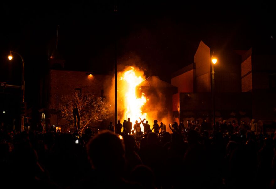 MINNEAPOLIS, MN - MAY 28: Protesters cheer as the Third Police Precinct burns behind them on May 28, 2020 in Minneapolis, Minnesota. As unrest continues after the death of George Floyd, police abandoned the precinct building, allowing protesters to set fire to it. (Photo by Stephen Maturen/Getty Images)