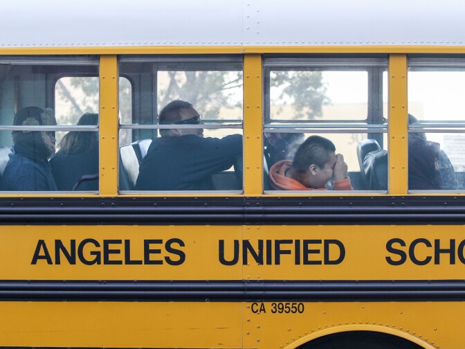 File: A school bus arrives at a school in Los Angeles on Dec. 16, 2015.