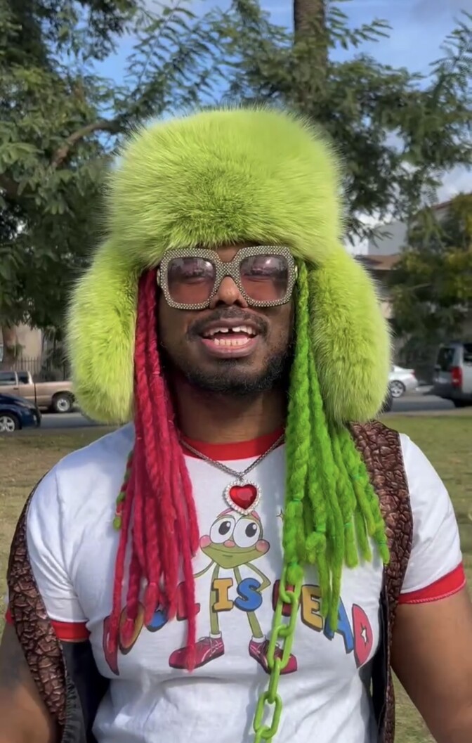A man with a green furry hat and big sunglasses.