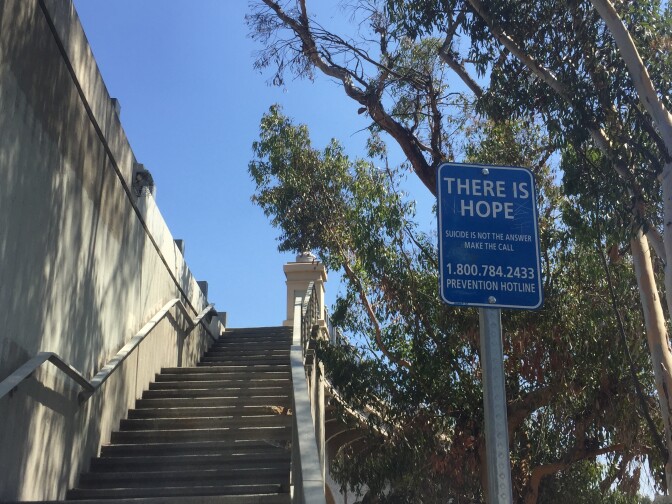 A sign below the Colorado Street Bridge offers suicide hotline information for those who may be thinking of taking their own lives.

