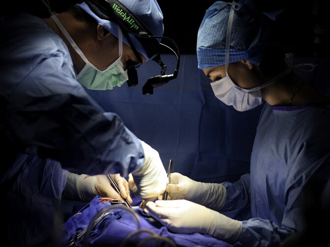 A surgeon (L) and an assistant surgeon perform an open-heart surgery in a cardiac surgery unit at the Angers hospital in Angers, western France, on October 24, 2013. The Angers hospital employs 6,000 people including 980 doctors. AFP PHOTO / JEAN-SEBASTIEN EVRARD (Photo credit should read JEAN-SEBASTIEN EVRARD/AFP/Getty Images)
