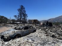 Rubble from a demolished home with vehicle out front are seen in the community of Squirrel Valley in Lake Isabella, California on June 24, 2016.