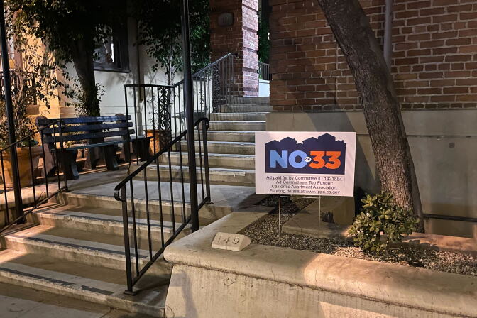A no on 33 sign is in the planter area outside an apartment building