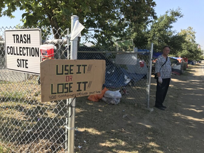 Orange County Public Works set up trash collection sites as part of the preliminary injunction in a lawsuit over the homeless encampment along the Santa Ana River. Pastor Donald Dermit, shown here, frequently ministers to the homeless.