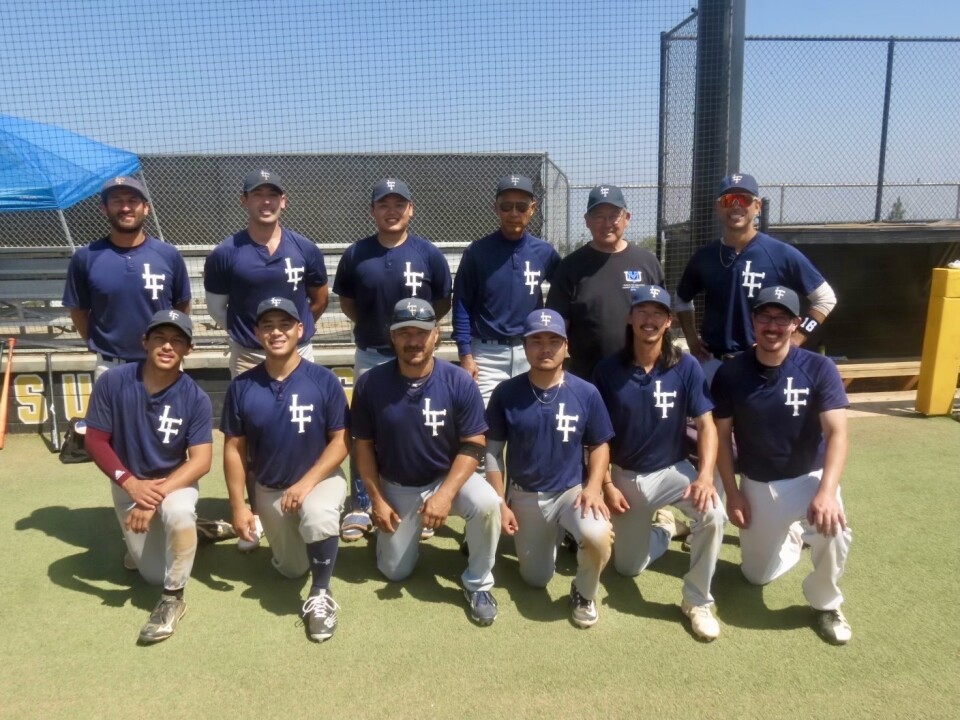 Twelve people of Asian descent pose wearing baseball hats and uniforms.