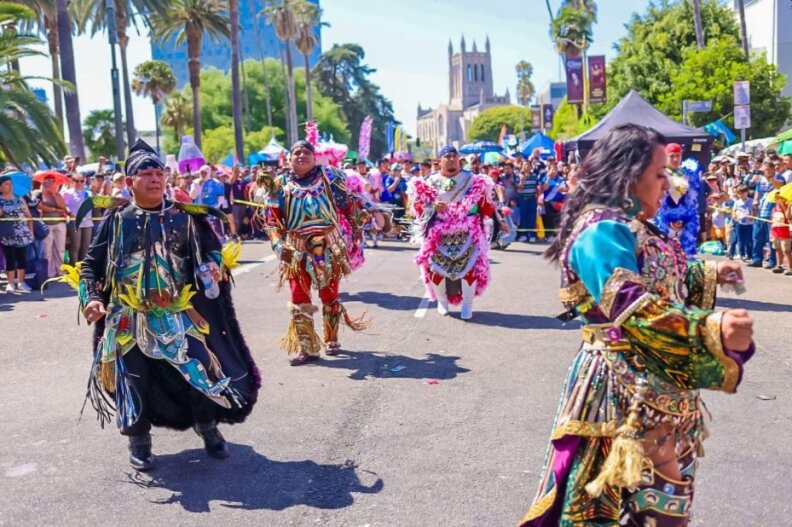 Men and women dance in traditional Guatemalan ensembles during a festival.