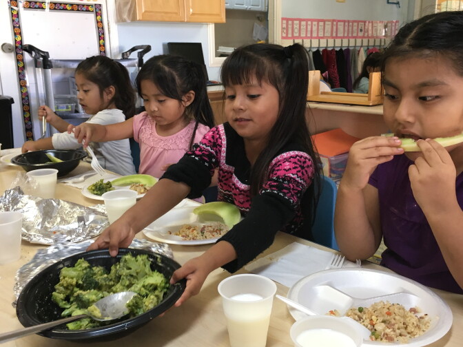 Preschoolers at La Estancia Head Start center eat broccoli and rice for lunch. To build healthy nutrition practices, children serve themselves and teachers talk about the foods as they eat. 