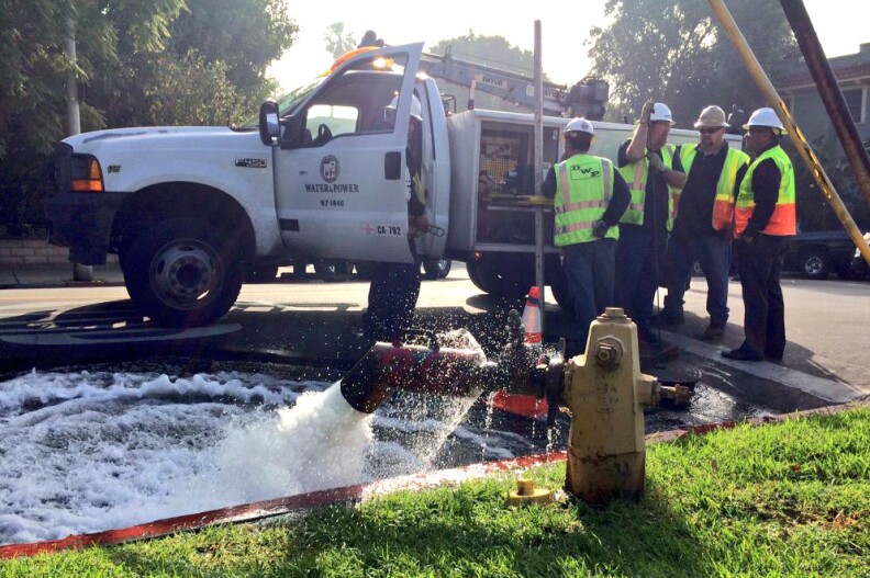 LADWP crews let pressure off the water main break on Dix Street and Holly Drive after a water main break submerged cars on Wednesday, February 18, 2015.