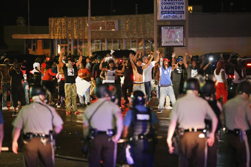Demonstrators taunt police during a protest over the shooting death of Michael Williams on Aug. 15, 2014 in Ferguson, Missouri, Police shot pepper spray,  smoke, gas and flash grenades at protesters before retreating. Several businesses were looted as the county police sat nearby with armored personnel carriers (APC). Violent outbreaks have taken place in Ferguson since the shooting death of Brown by a Ferguson police officer on Aug. 9.