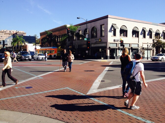 Pedestrians take the diagonal crosswalk on Colorado Boulevard and Raymond Avenue in Old Town Pasadena. 