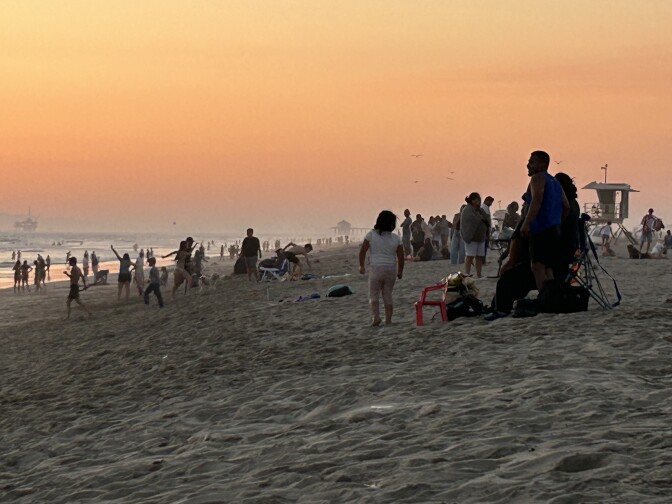 A crowded beach at sunset