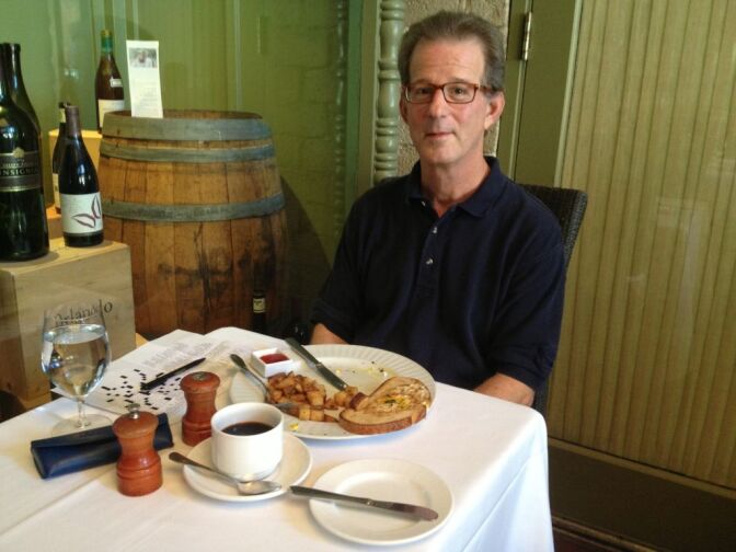 Albert Tumpson sits with his New York Times crossword puzzle and the remains of potatoes and toast from brunch. He has been frequenting Campanile since 1993. Over the years, he's come alone, with friends, for birthdays, and with his wine group.