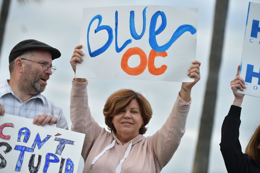 Supporters of Democratic Congressional candidate for California's 48th District Harley Rouda, hold signs and cheer at a get-out-the-vote rally in Laguna Beach, California on election day November 6, 2018. - Rouda is running to unseat longtime incumbent Rep. Dana Rohrabacher, (R-Huntington Beach) in one of the pivotal battles in Orange County, the outcome of which will help determine if Democrats regain control of the House of Representatives. Americans started voting Tuesday in critical midterm elections that mark the first major voter test of US President Donald Trump's controversial presidency, with control of Congress at stake. (Photo by Robyn Beck / AFP)        (Photo credit should read ROBYN BECK/AFP/Getty Images)