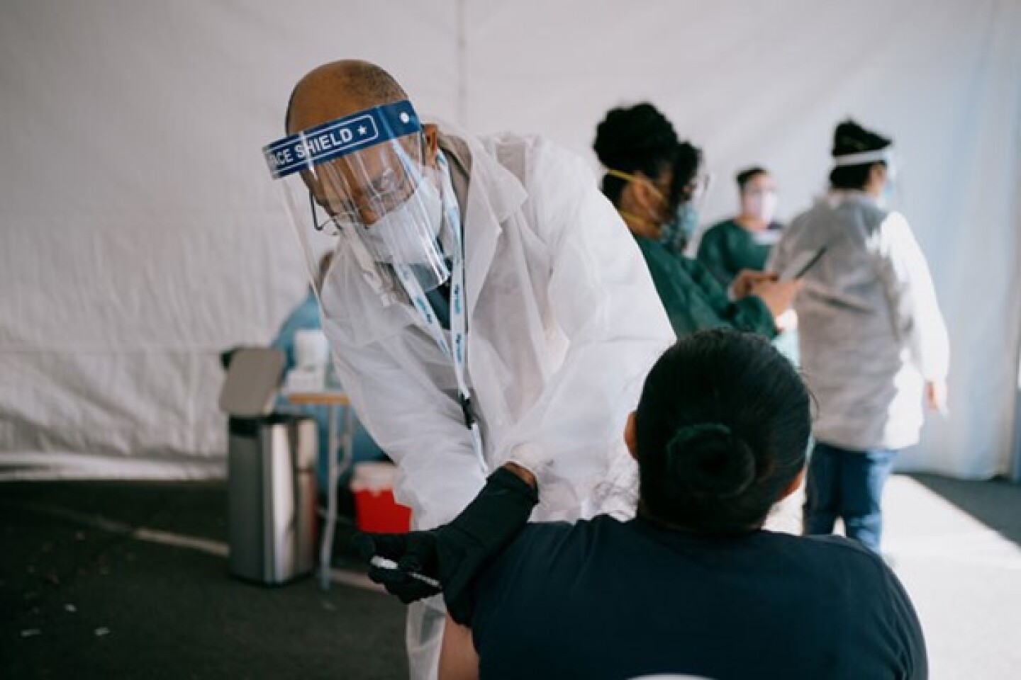 UC President Michael Drake, who is a physician, administering the COVID-19 vaccination