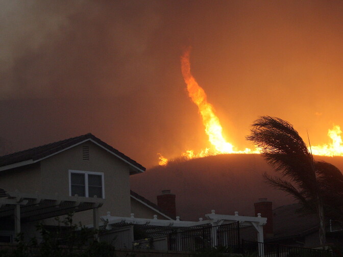 YORBA LINDA, CA - NOVEMBER 15:  A fire tornado comes close to homes during the Corona Fire on November 15, 2008 in Yorba Linda, California. Strong Santa Ana Winds are destroying hundreds of homes and charring thousands of acres around southern California. California Governor Arnold Schwarzenegger has declared states of emergency for the fires.  (Photo by David McNew/Getty Images)
