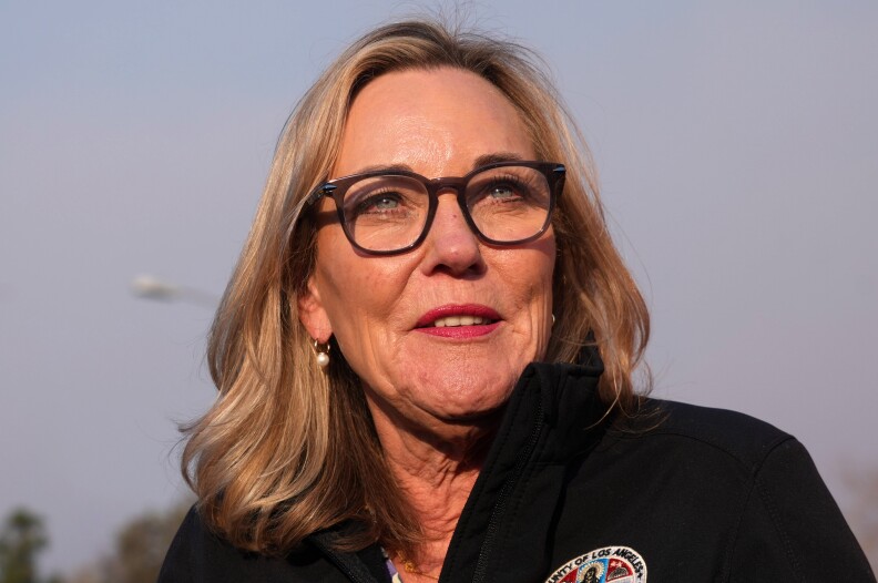 A close up shot of a woman with shoulder length blonde hair and dark rimmed glasses.