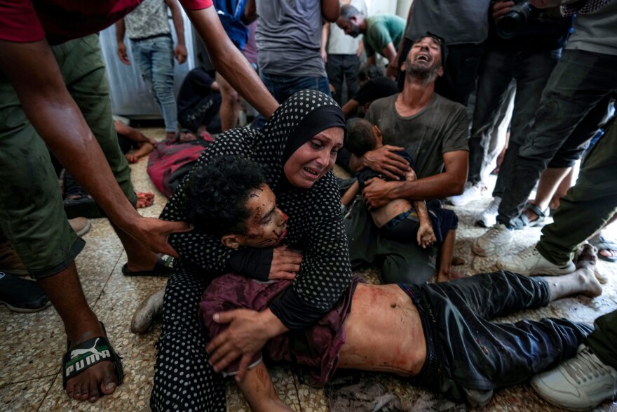 A grieving woman holds a man's body.
