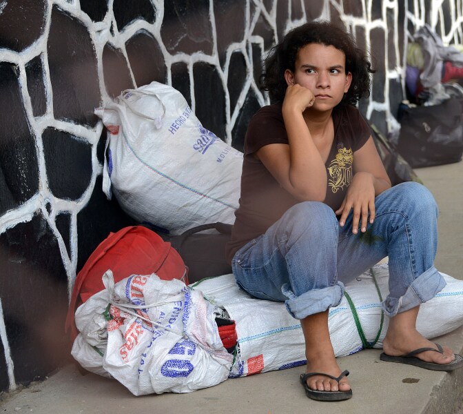 A young girl waits for her family upon arriving to San Pedro Sula, 240 kms north of Tegucigalpa, on July 2, 2014, after being deported from the US. Thousands of unaccompanied children, most of them from Central America, have trekked to the United States in recent months and now face deportation in what the United States has called a humanitarian crisis. 