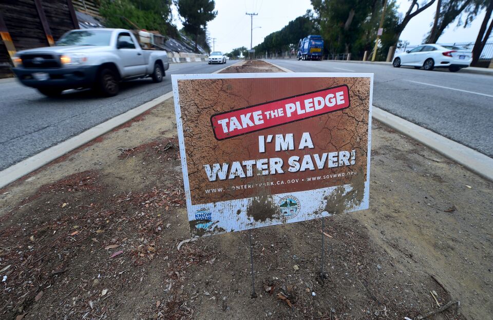 File: A water conservation sign remains in what was once a grass-covered traffic divider in Montery Park, California on May 19, 2016. 