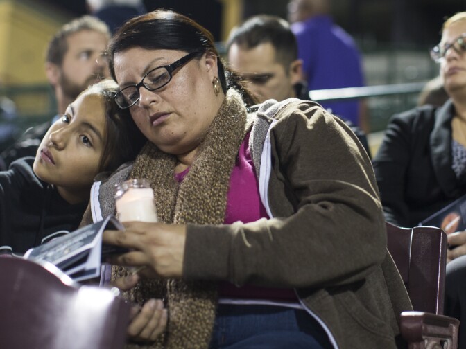 Celeste Guido, 11, left and mother Karina Gomez light candles before a vigil at San Manuel Stadium in San Bernardino on Thursday night, Dec. 3, 2015 following a mass shooting that left 14 people dead and 21 injured on Wednesday at the Inland Regional Center. "This city has been really good to us," Karina Gomez said. Her family has lived in San Bernardino for five years.