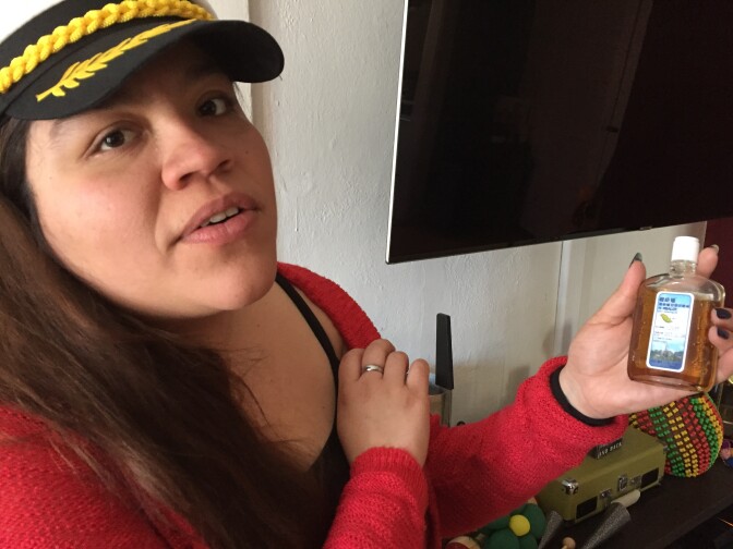 Carmen Morales shows an herbal remedy she uses to treat back and knee pain.