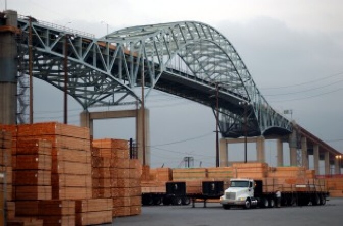 A truck loads up with imported lumber near Long Beach's Gerald Desmond Bridge on March 29, 2002. A new $1 billion project will replace the now 42-year-old bridge. It is expected to rise alongside the existing one and be ready for traffic in six years.
