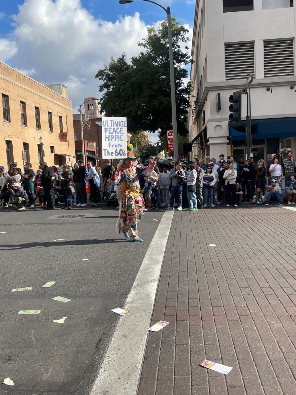A person holds a sign that says "ultimate peace hippie from the 60s."