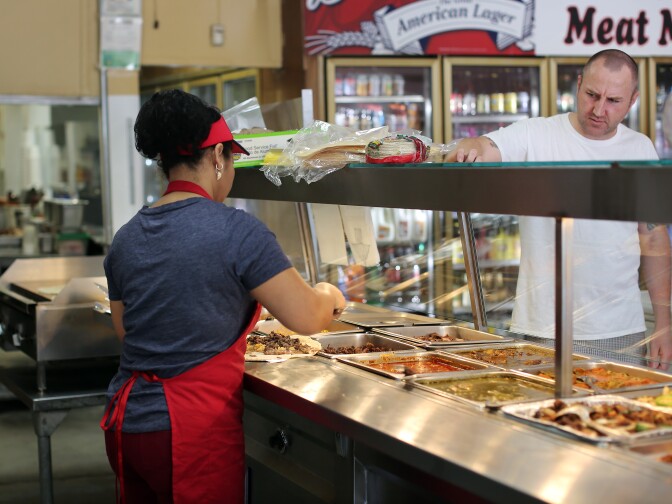 Poncitlan cook Enedina Arrellano makes a to-go order for a customer. Owner Irma Leticia Vega stopped selling groceries at the store because she couldn't compete on price. She decided to focus on authentic Mexican food, something Walmart and Super King don't have.
