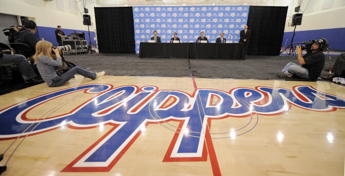 The Los Angeles Clippers logo is displayed as newly acquired point guard Chris Paul, second from center left, appears during an NBA basketball news conference to introduce him on Thursday, Dec. 15, 2011, in Los Angeles.  (AP Photo/Mark J. Terrill)