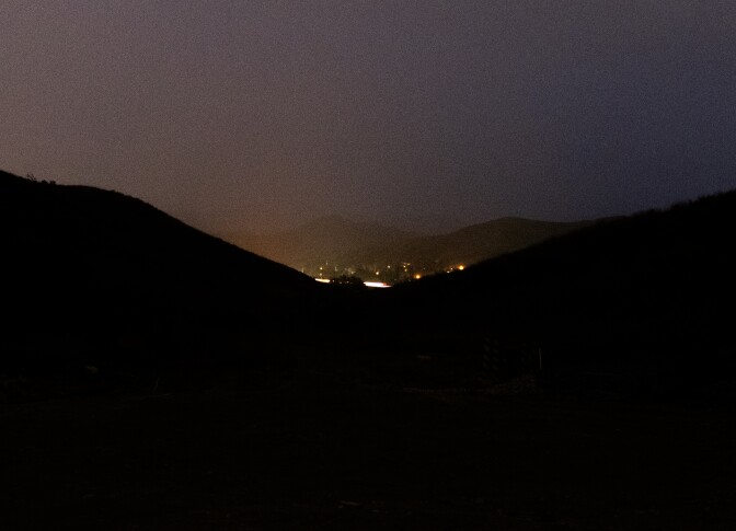 Dark hills at night with lights.