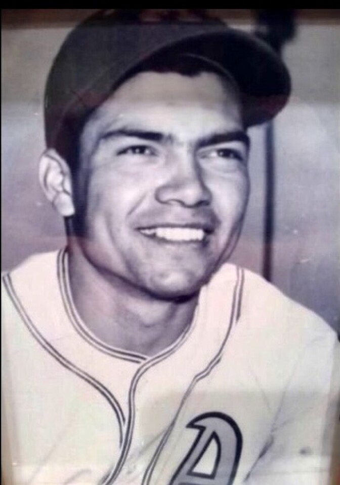 A headshot of a smiling man in a baseball jersey and cap.