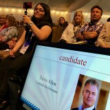 Attendees of the California Republican Party convention watch gubernatorial candidate Travis Allen on stage in San Diego.