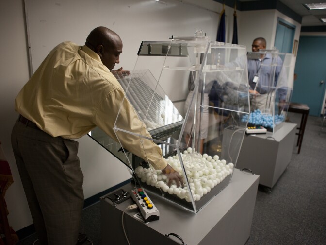 Michael Young (L) and Vince McClure (R), program analysts at the Selective Service, do final checks on the draft lottery machines prior to their monthly test.