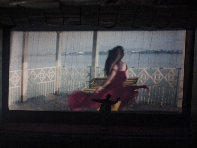 A member of the audience dances below the screen at Temorshahee Cinema in the old city of Kabul, June 2011.