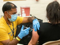 A woman receives a COVID-19 vaccine at Ted Watkins Memorial Park in Watts, Los Angeles on May 5th 2022