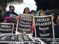 Two young attendees of an anti-Trump rally, led by the United Teachers Los Angeles labor union, hold signs ahead of a march on Jan. 19, 2017.