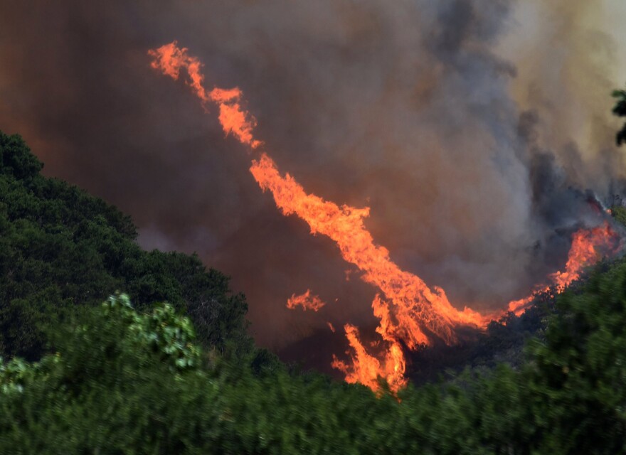 This Saturday, July 8, 2017, photo provided by the Santa Barbara County Fire Department shows a large fire whirl developing from erratic winds near Tepesquet Road in a wildfire east of Santa Maria, Calif., in Santa Barbara County, Calif. Wildfires barreled across the baking landscape of the western U.S. and Canada, destroying a smattering of homes, forcing thousands to flee and temporarily trapping children and counselors at a California campground. Southern California crews hope slightly cooler temperatures and diminishing winds will help in the battle Sunday. (Mike Eliason/Santa Barbara County Fire Department via AP)