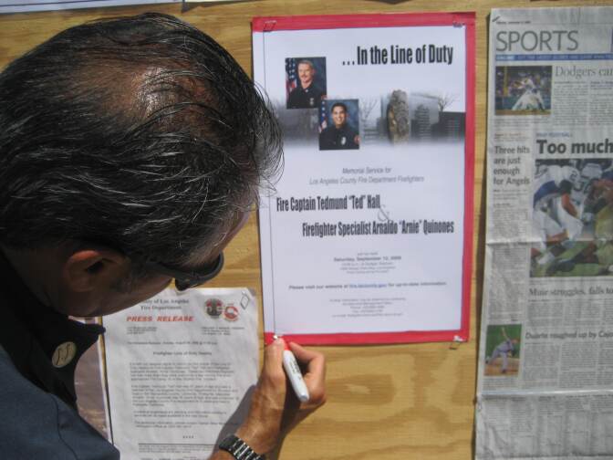 Carlos Guerrero of the Glendale Fire Department posts notice of Memorial Service for firefighters Ted Hall and Arnie Quinones.