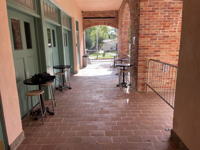 An outside space with bar stools and high tables.