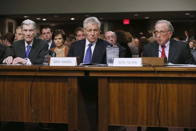 Former U.S. Sen. Chuck Hagel (R-NE) (C) listens to former U.S. Sen. John Warner (R-VA) (L) and former U.S. Sen. Sam Nunn (D-GA), both former chairmen of the Senate Armed Services Committee, as they deliver openingn remarks during Hagel's confirmation hearing to become the next secretary of defense before the committee January 31, 2013 on Capitol Hill in Washington, DC.  President Barack Obama nominated Hagel, a controversial choice as Hagel opposed former President George W. Bush and his own party on the Iraq War and upset liberals with his criticism of a gay ambassador, for which he later apologized. 