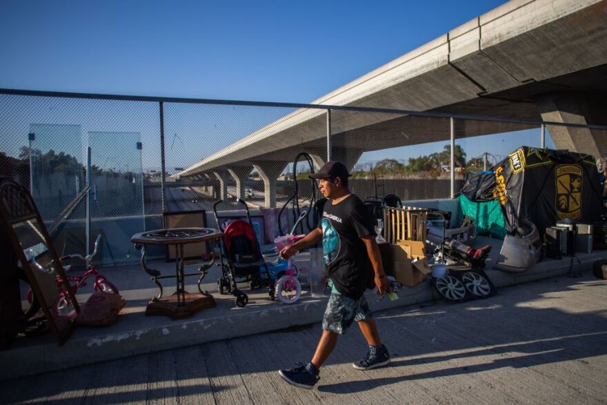 An unemployed upholsterer, Israel Yaxon 28 years-old, who has lived for one year on the street, walks outside his tent over the bridge of the 110 Freeway, during the novel Coronavirus, COVID-19, pandemic in Los Angeles California on May 25, 2020. - On May 22, 2020 a federal judge issued a preliminary order requiring that  homeless people living under Los Angeles freeway overpasses and underpasses, be relocated for health and safety reasons. (Photo by Apu GOMES / AFP) (Photo by APU GOMES/AFP via Getty Images)